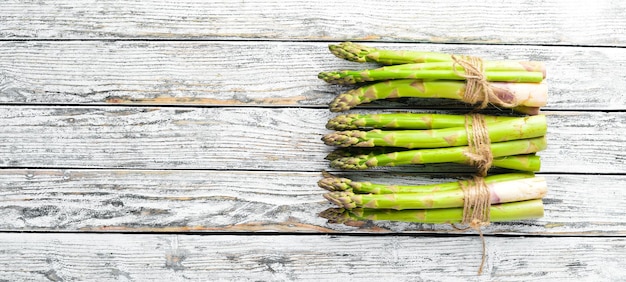 Foto asparagi verdi freschi su fondo di legno bianco. cibo salutare. vista dall'alto. spazio libero per il tuo testo.