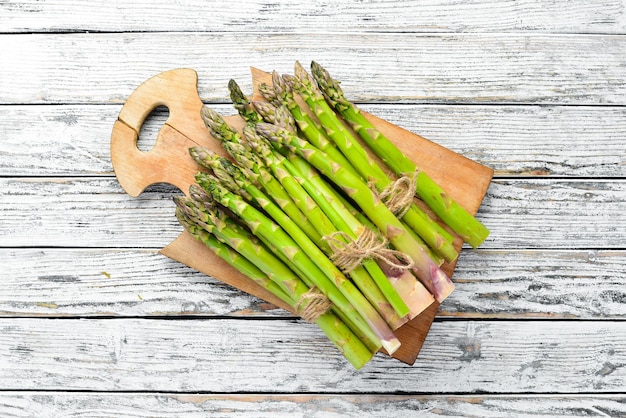 Fresh green asparagus on a white wooden background Healthy food Top view Free space for your text