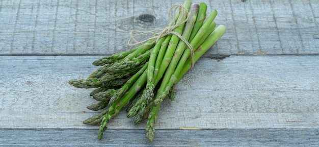 Fresh green asparagus on wooden background,front view.