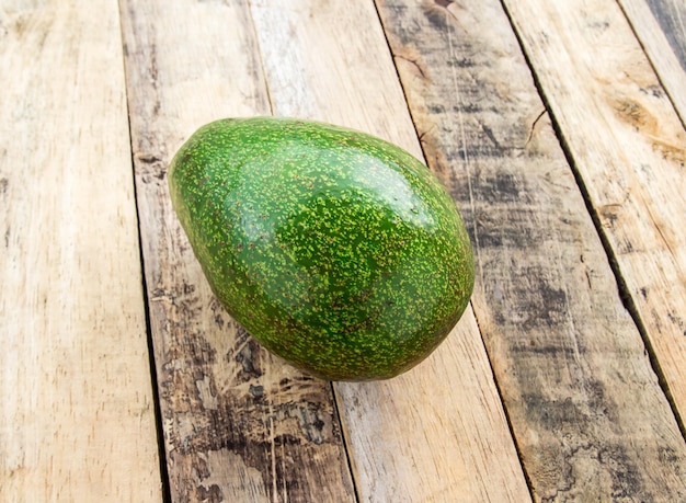 Fresh green avocado on wooden table