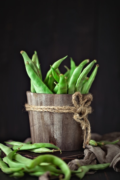 Photo fresh green beans on a wooden table.