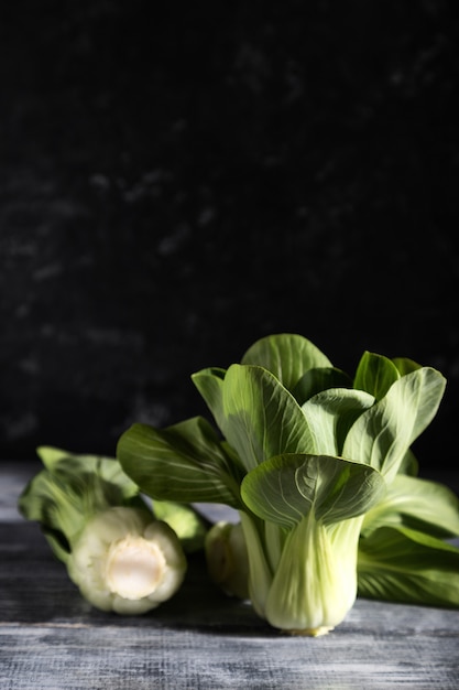 灰色の木の表面に新鮮な緑のチンゲン菜または白菜