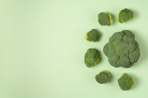 Verdure di broccoli verdi freschi su testa di cavolo di broccoli sole verde pallido su uno sfondo colorato