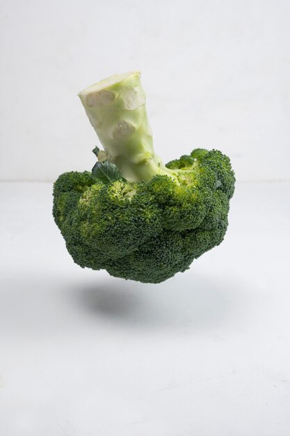 Fresh green broccoli on white wooden table.