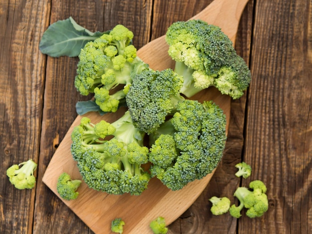 Fresh green broccoli on a wooden cutting board with a knife Broccoli cabbage leaves