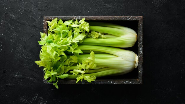 Fresh green celery in a wooden box Healthy food Top view Free space for your text