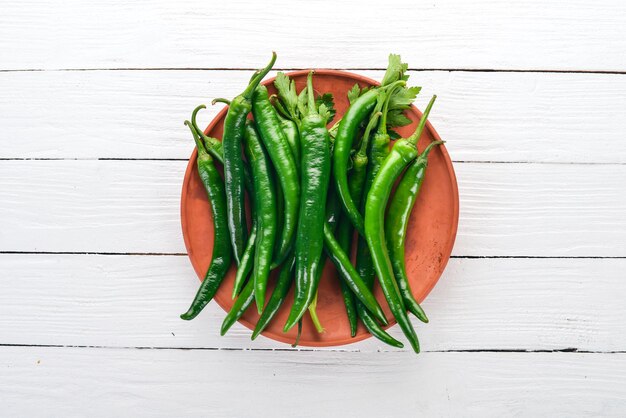 Fresh green chilli On a white wooden background Top view Free space for text