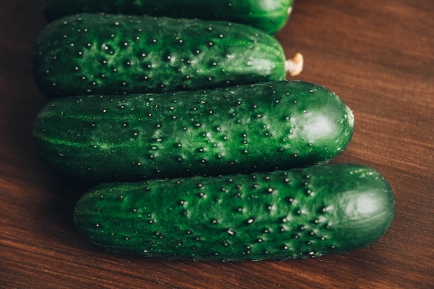 Fresh green cucumbers on a wooden table background. Top view. Copy, empty space for text