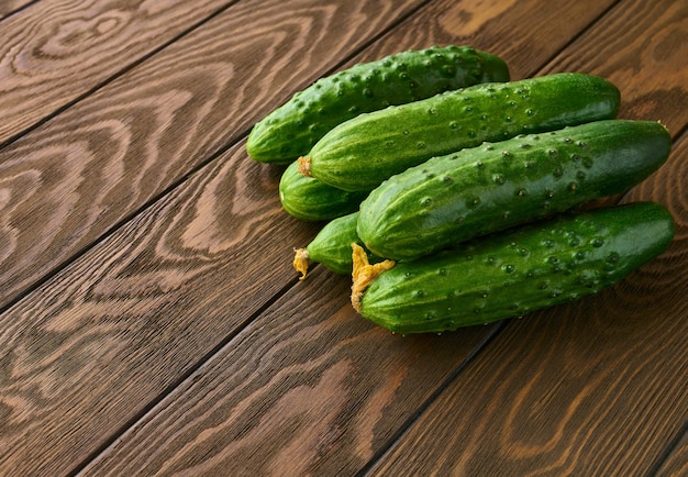 Fresh green cucumbers on a wooden table close up