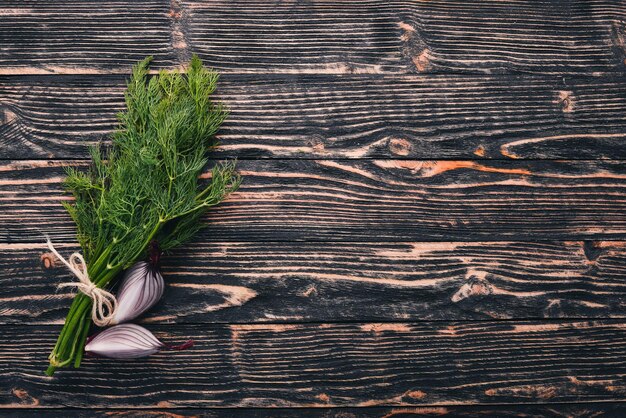 Fresh green dill on a wooden background. Top view. Free space for your text.