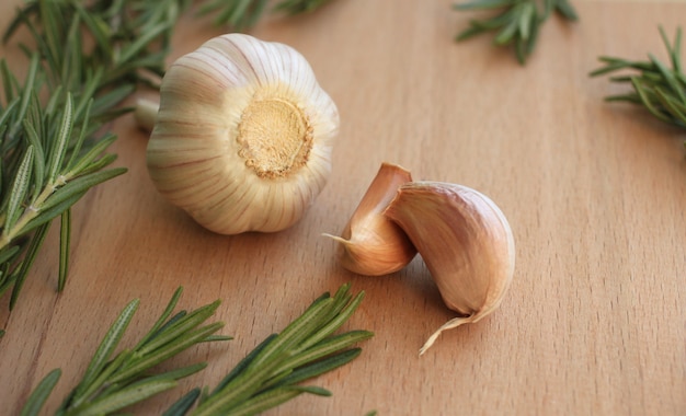 fresh green fluffy rosemary sprigs with garlic on a beige background