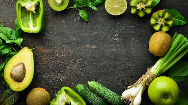 Fresh Green Fruits and Vegetables Pure selection and source of vegetable protein on a wooden aged background Avocados grapes cucumbers kiwi apples lime green pepper