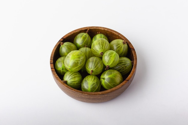 Fresh green gooseberry berries on a white background