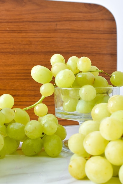 Fresh Green Grapes in An Ice Cream Glass with Browny Wood Background