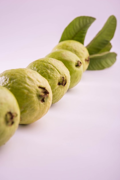 힌디어 암루드(Amrood), 마라티어 페루(Peru)라고도 하는 신선한 녹색 구아바 과일은 바구니 전체로 제공되거나 다채로운 배경 위에 조각으로 제공됩니다. 선택적 초점