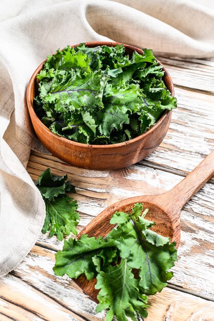 Fresh green kale leaves in a wooden bowl