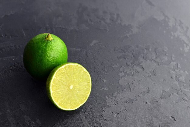 Fresh green limes on black slate