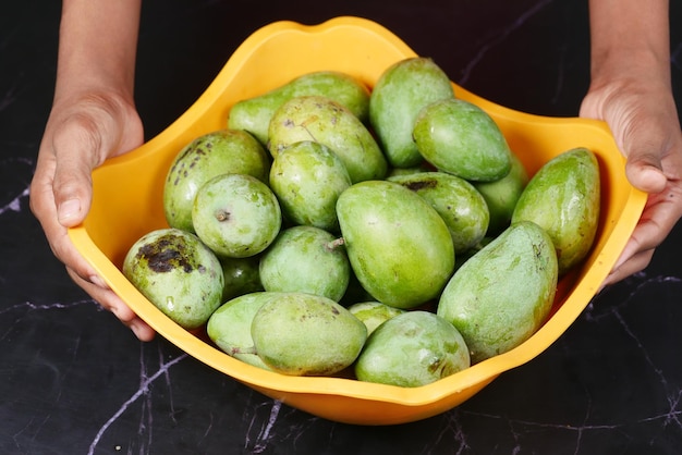 Mango verde fresco in una ciotola sul tavolo