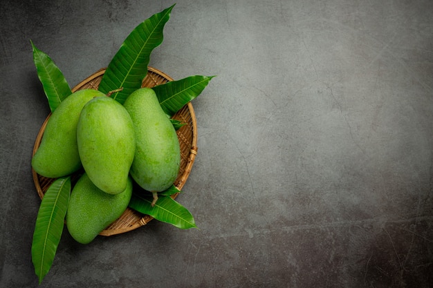 Fresh green mango on dark surface