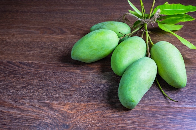 Fresh green mango fruit on a wooden table