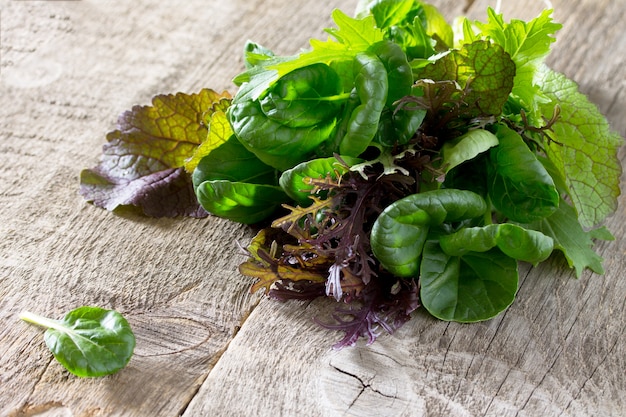 Fresh green mixed salad on a wooden table