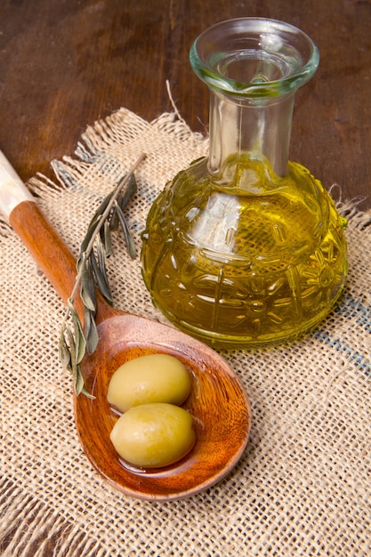 fresh green olives on spoon and oil