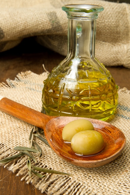 fresh green olives on spoon and oil