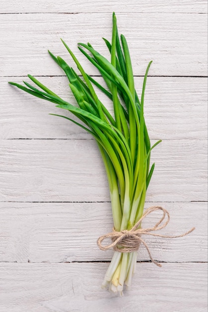 Photo fresh green onion on a wooden background top view free space for your text