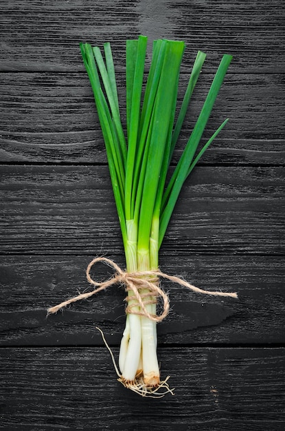 Fresh green onion on a wooden background Top view Free space for your text