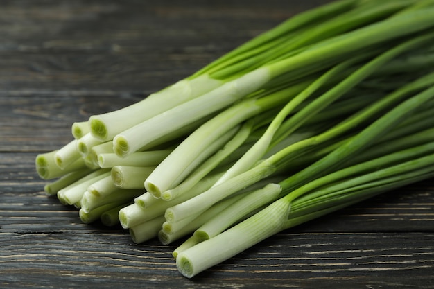 Fresh green onion on wooden table, close up