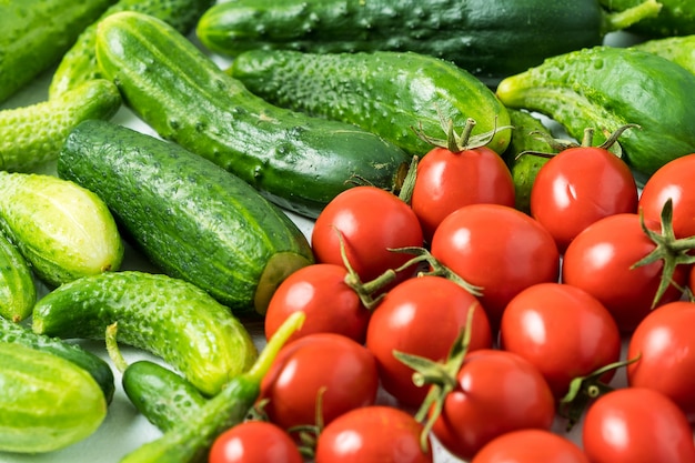 Fresh green organic cucumber and red tomato background.