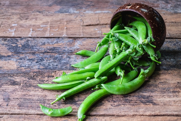 Fresh green pea in bowl on wooden background