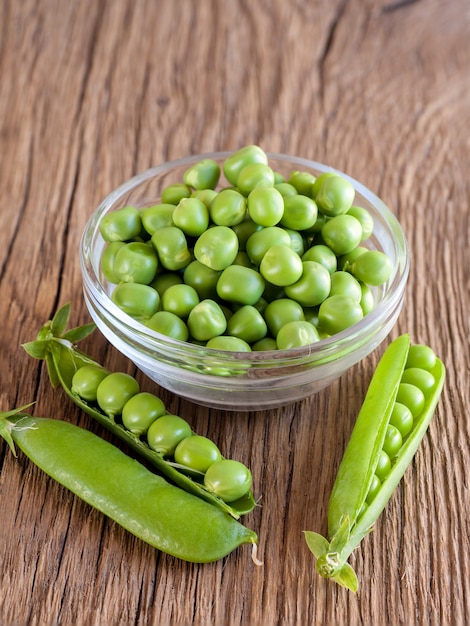 Fresh green pea in a bowl on wooden table