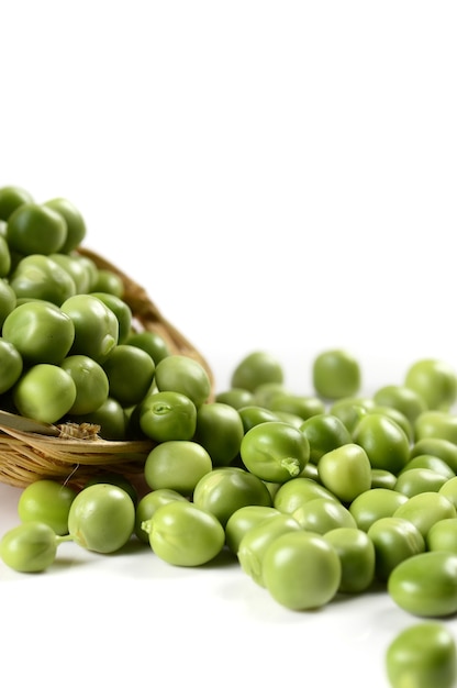 Fresh Green Peas in basket on white surface