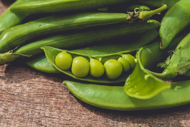 Fresh green peas or beans on wooden table