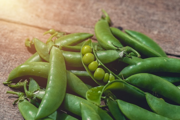 Fresh green peas or beans on wooden table