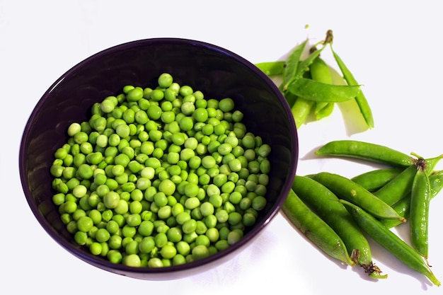 Fresh green peas in bowl against white background