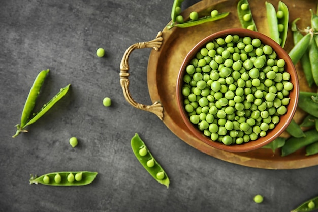 Fresh green peas in bowl on tray