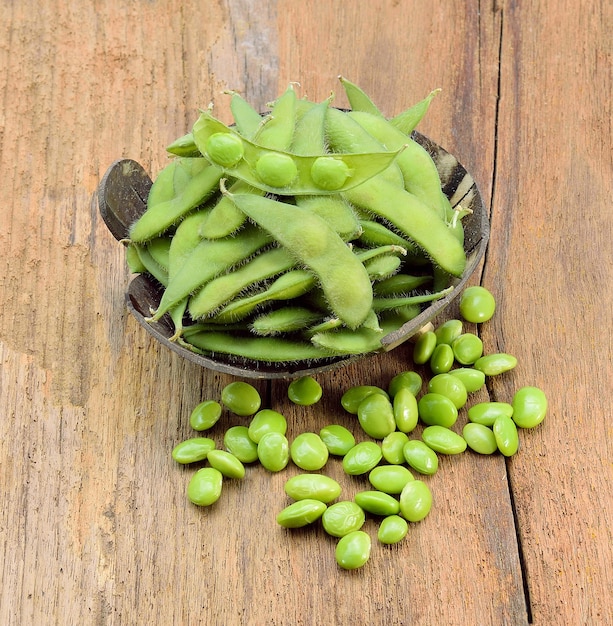 Fresh green peas in bowl on wooden