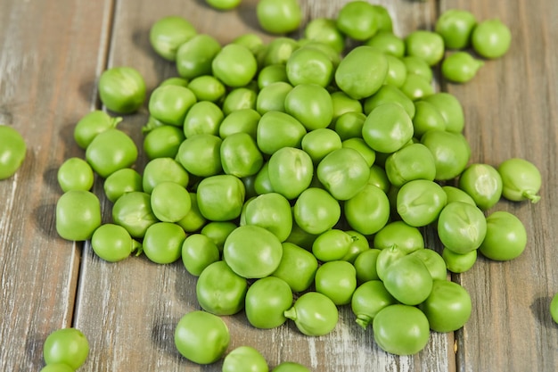 Fresh green peas heap on wooden background