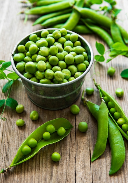 Fresh green peas in the small metal bucket