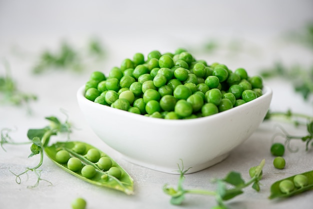 Fresh green peas in a white bowl