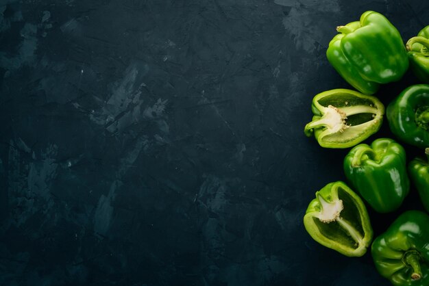 Fresh green pepper in a wooden box On a black stone background Top view Free space for text