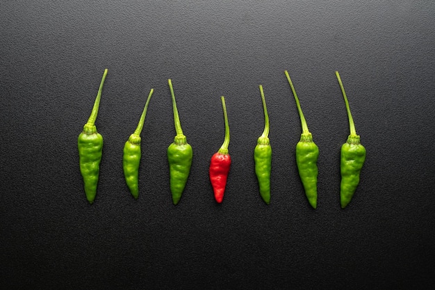 Fresh green and red chili isolated on black dramatic background