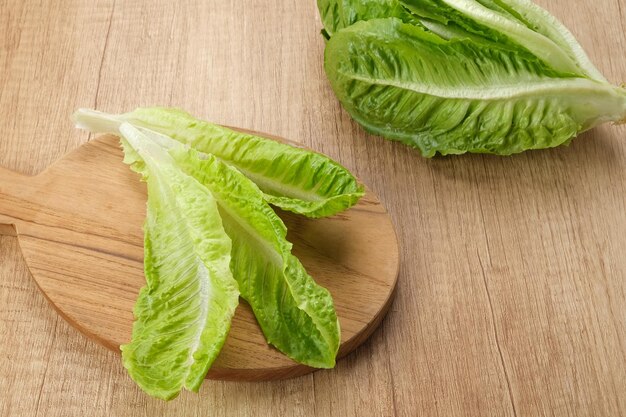 Fresh green romaine lettuce on a wooden background