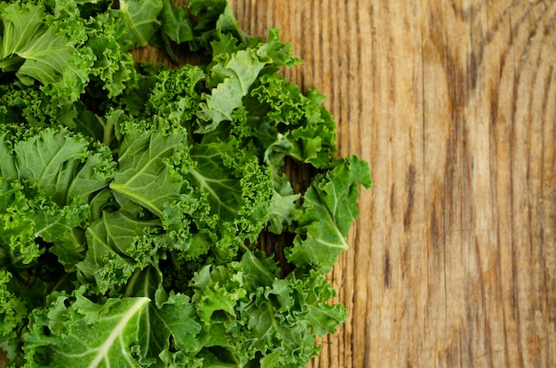 Fresh green sabellica leaves on wooden background, healthy organic food. Studio Photo