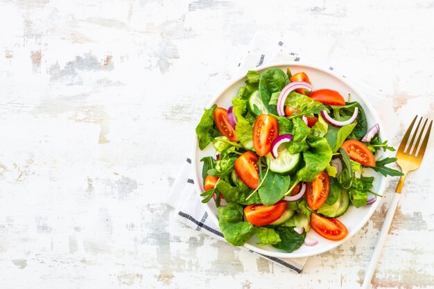 Foto insalata verde fresca con foglie e verdure rucola spinaci pomodori e cipolla