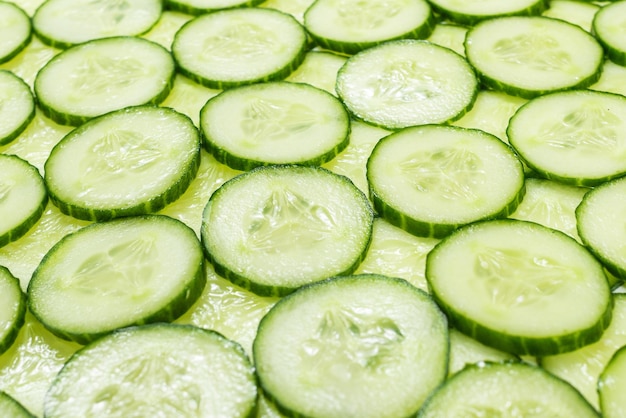 Fresh green slices of cucumber as background. Top view.