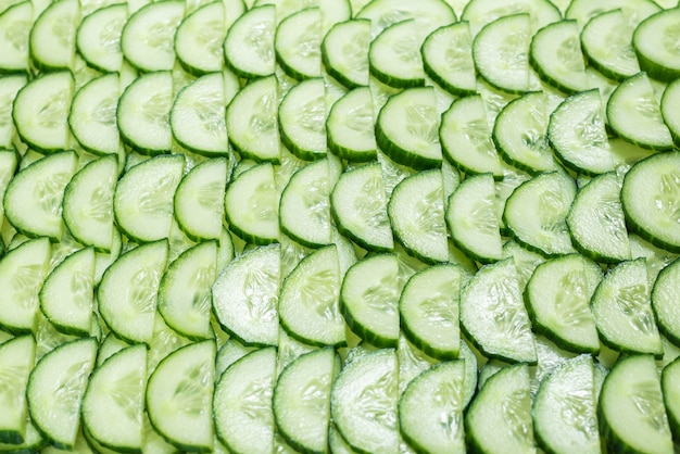 Fresh green slices of cucumber as background. Top view.