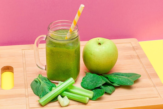 Fresh green smoothie of apple celery and spinach in glass smoothie jar